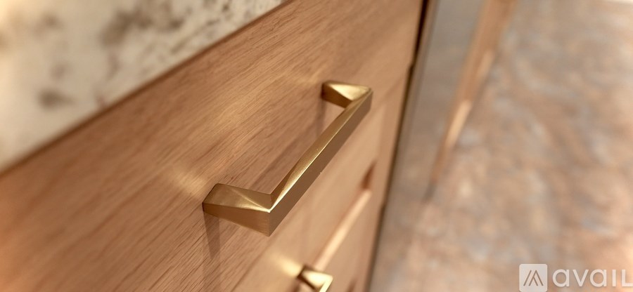 A close up of a wooden drawer with a brass handle.