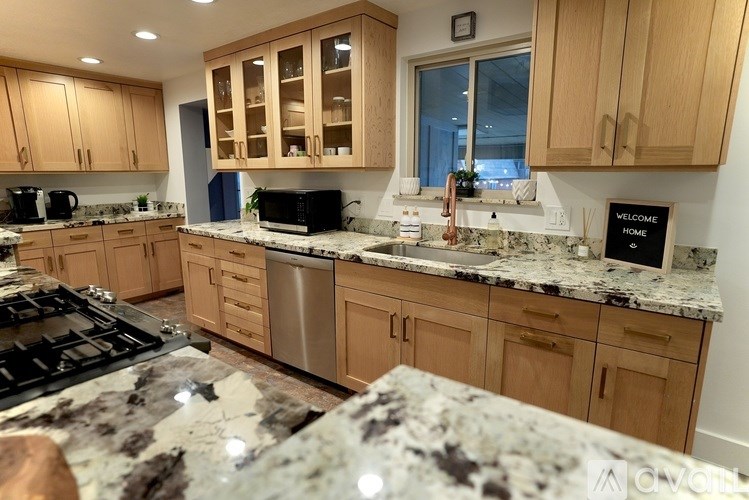 A kitchen with granite countertops and wooden cabinets.