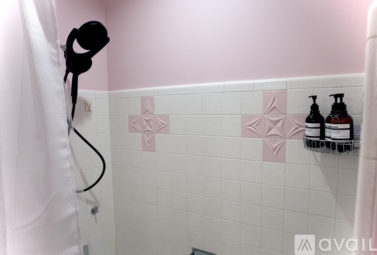A bathroom with pink walls and a white shower curtain.