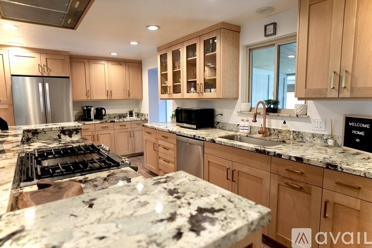 A kitchen with granite countertops and wooden cabinets.
