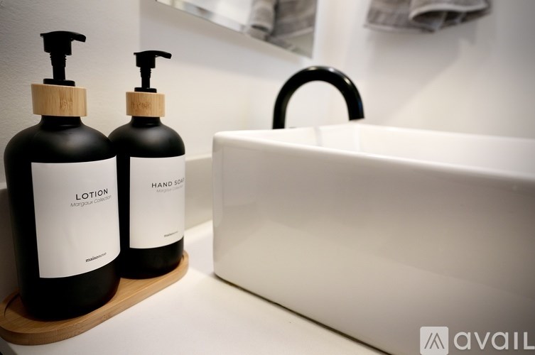 Two bottles of lotion and hand soap on a wooden tray.