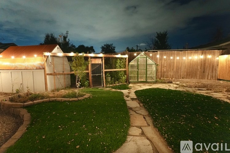 A backyard with a lawn, a shed, and a fence.