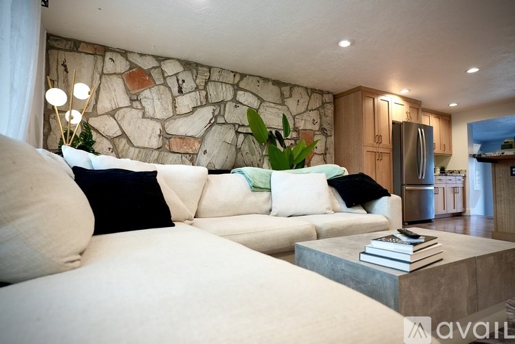 A living room with a stone wall and a large white couch.