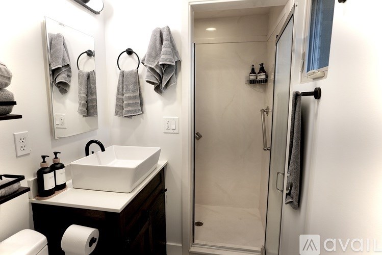 A bathroom with a white sink and toiletries on a counter.