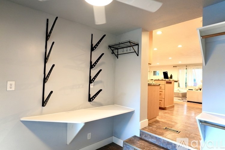 A white shelf with black brackets is mounted on a white wall.