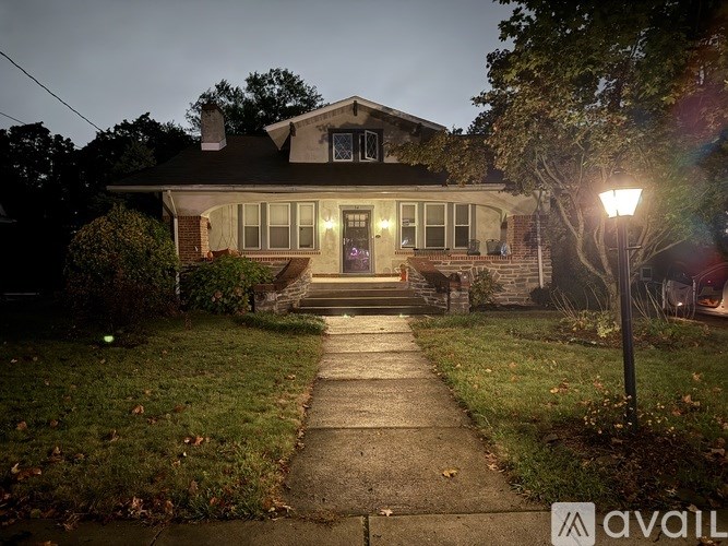 A house with a front porch and a sidewalk leading to it.