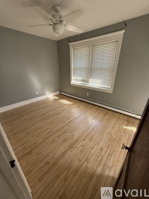 A room with wooden flooring and a ceiling fan.