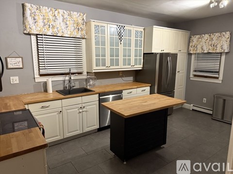 A kitchen with a wooden island in the middle of it.
