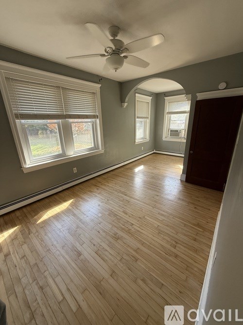 A room with wooden flooring and a ceiling fan.