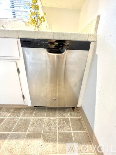 A dishwasher is in a kitchen under a counter.