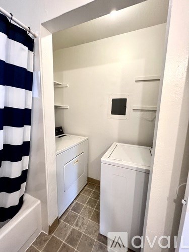 A small bathroom with a toilet and a washing machine.