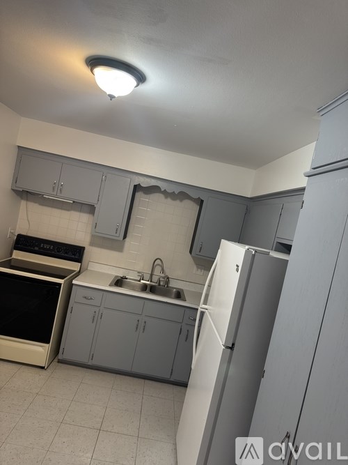 A kitchen with a sink, stove, and refrigerator.
