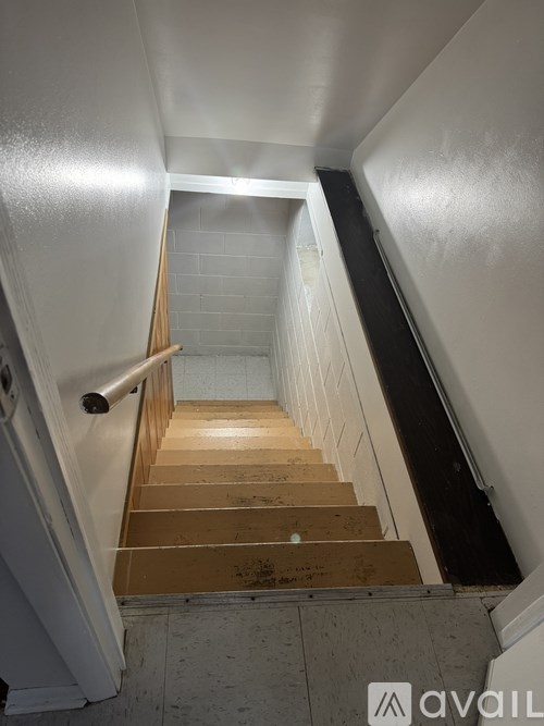 A staircase with wooden steps and a metal handrail.