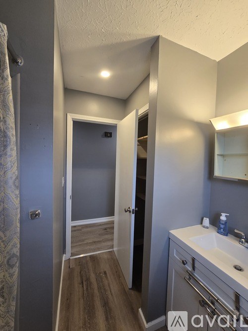 A bathroom with a blue wall and wooden flooring.