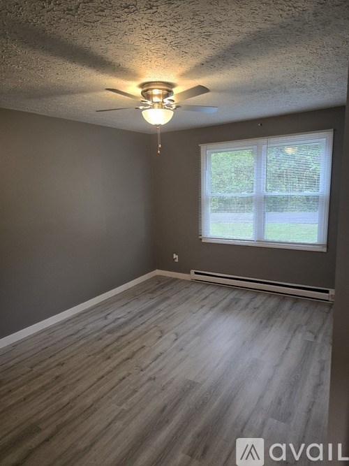A room with a ceiling fan and a window.