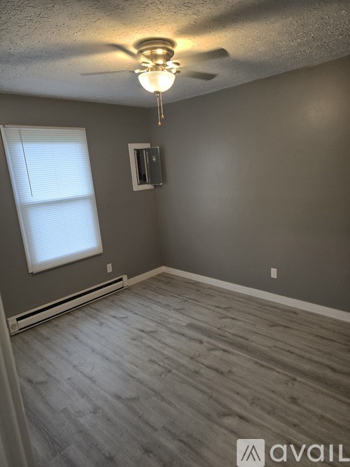 A room with a ceiling fan and a window.