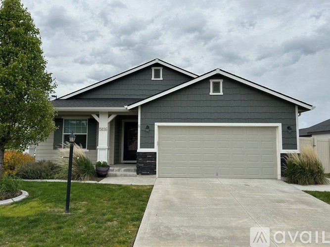 A house with a grey garage door is for sale.