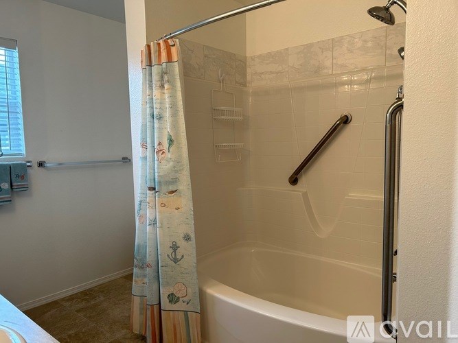 A bathroom with a shower curtain and a shower head.