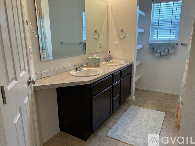 A bathroom with a sink, mirror, and cabinets.