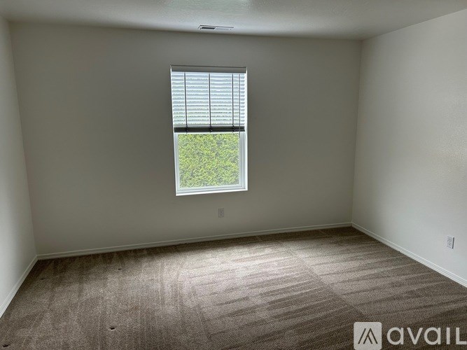 A room with a window and carpeted floor.