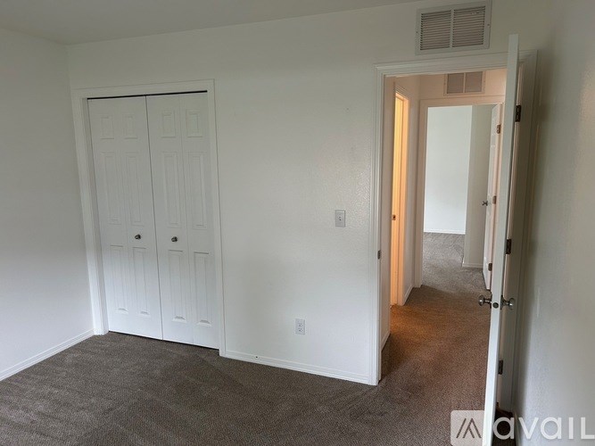 A room with a carpeted floor and a white door.