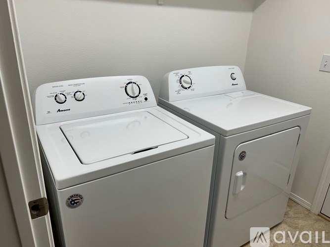 A white washing machine and dryer are in a small room.