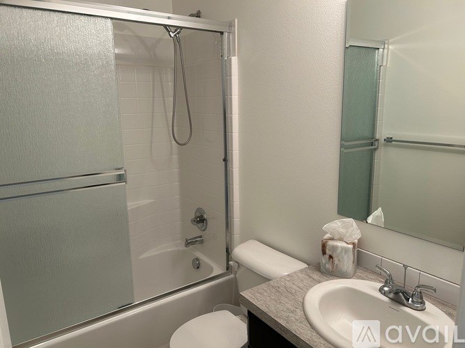 A bathroom with a toilet, sink, and shower.