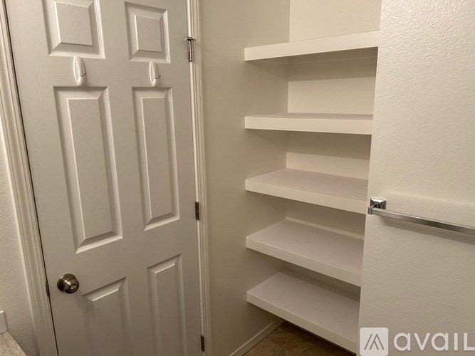 A white door with a set of shelves to the right.