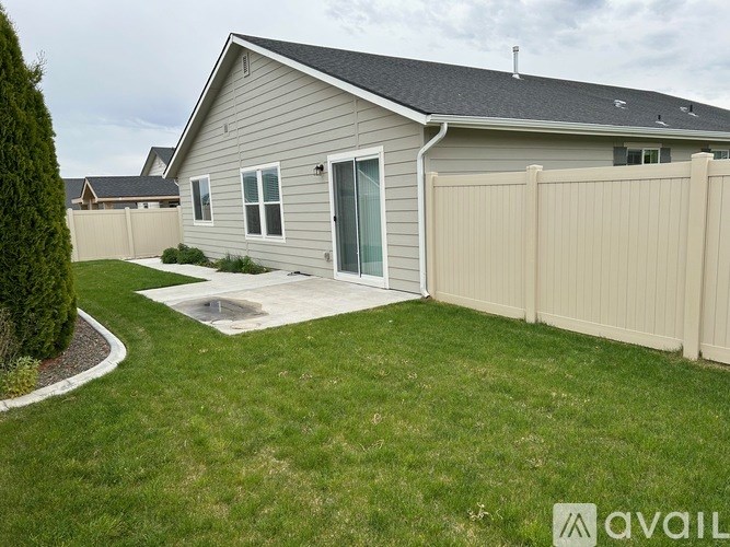 A house with a grey roof and a beige fence.