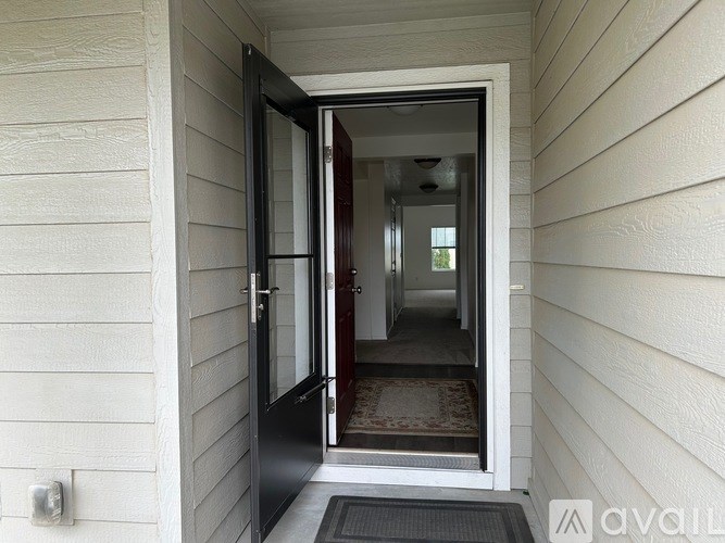 A black door is open to a hallway.