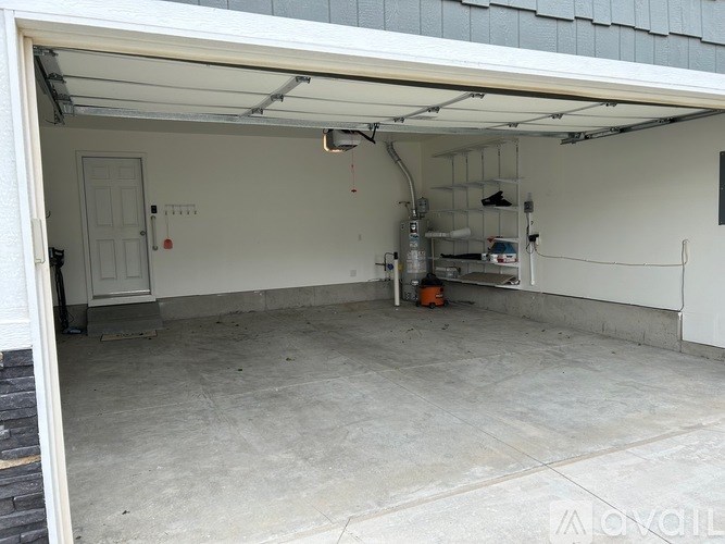 A garage with a white door and a concrete floor.