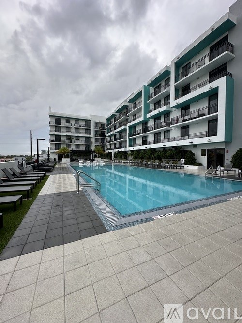 A large swimming pool in front of a multi-story apartment building.