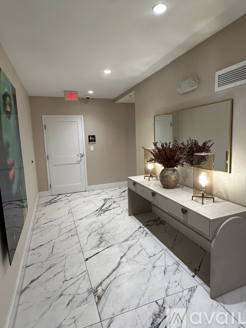A marble floor in a hallway with a bench and a mirror.