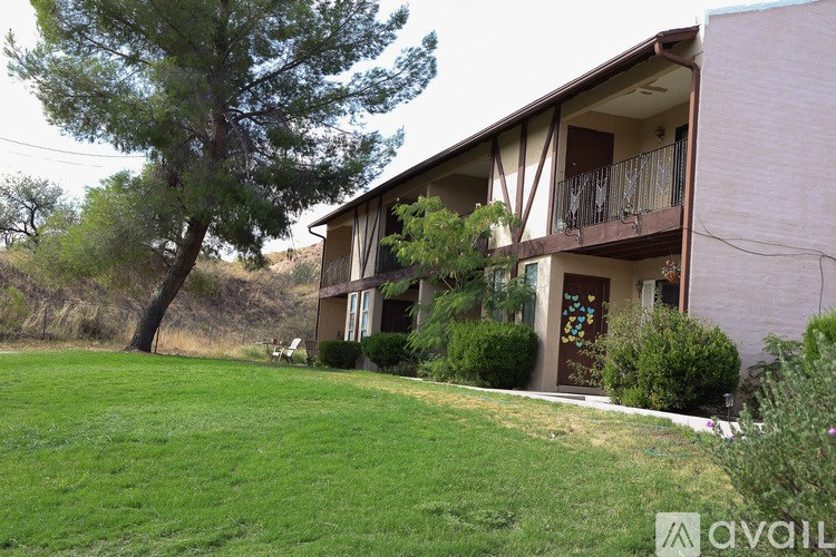 A house with a balcony and a tree in front.