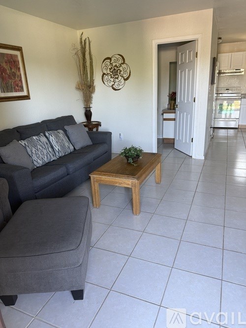 A living room with a grey couch and a wooden coffee table.