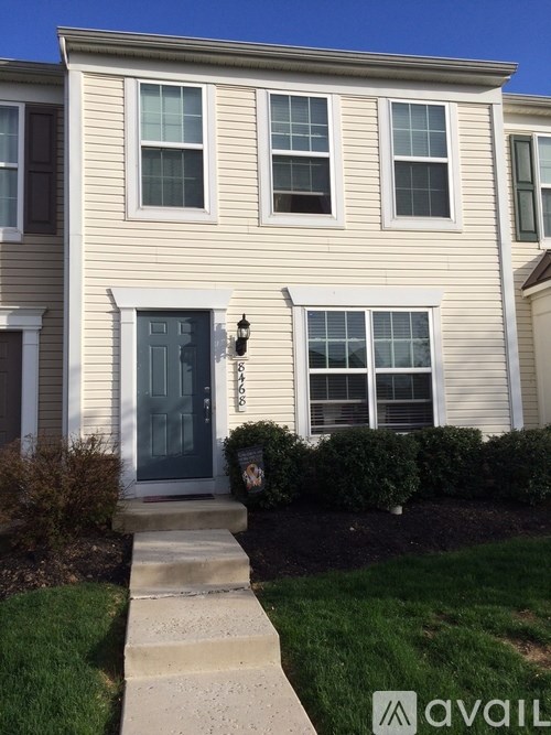 A house with a grey door and a small garden in front.