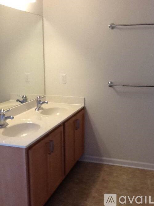 A bathroom with a double sink vanity and a mirror.