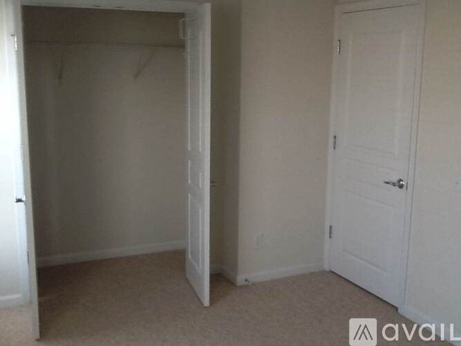 A room with a carpeted floor and two white doors.