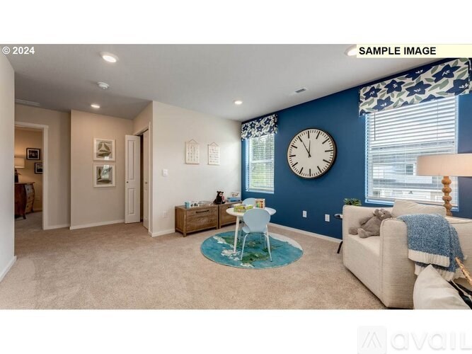 A living room with a beige sofa, a round rug, and a clock on the wall.