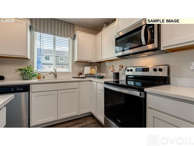 A kitchen with white cabinets and a black oven.