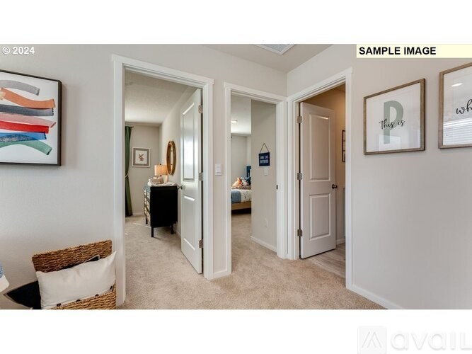 A room with a painting on the wall and a doorway leading to another room.