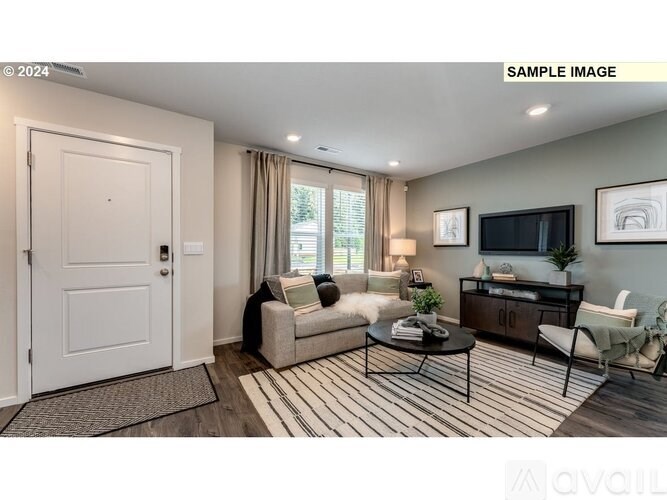 A living room with a white door, a sofa, a coffee table, and a television.