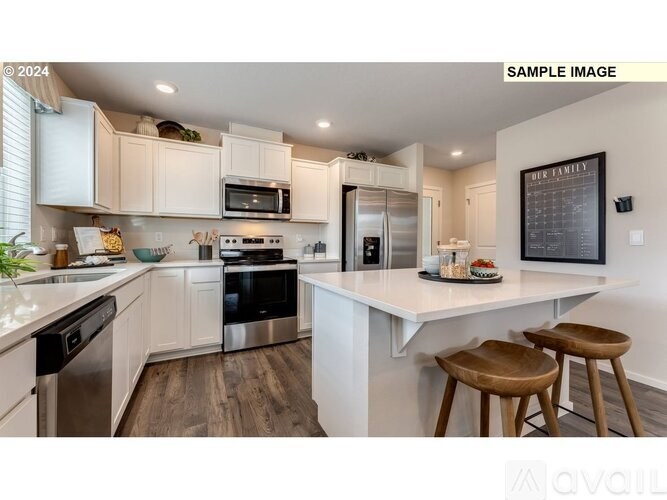 A modern kitchen with white cabinets and stainless steel appliances.