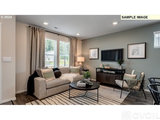 A living room with a couch, chair, and television.