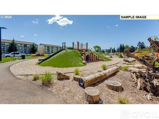 A playground with a green hill and wooden logs.