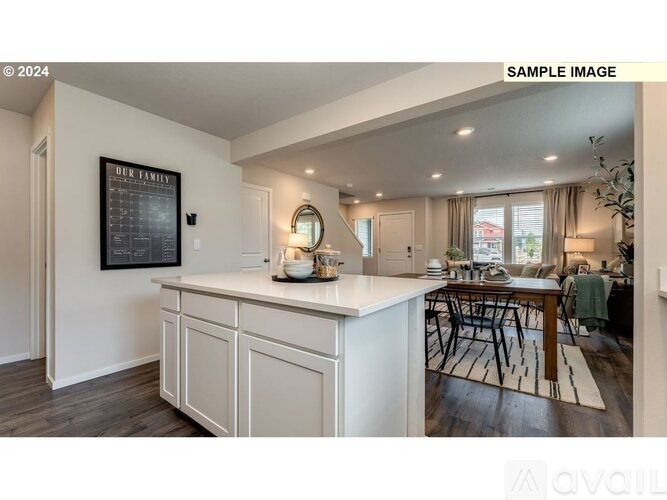 A kitchen with a white countertop and a framed picture on the wall.