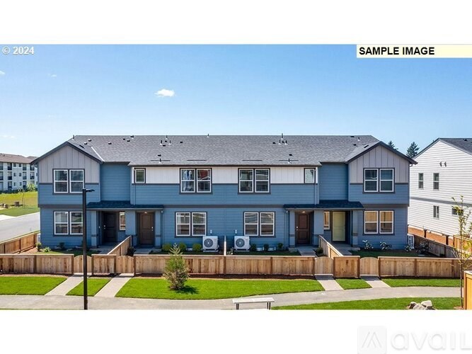 A blue house with a white fence in front.