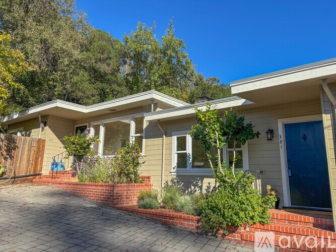 A house with a blue door and a brick wall in front.