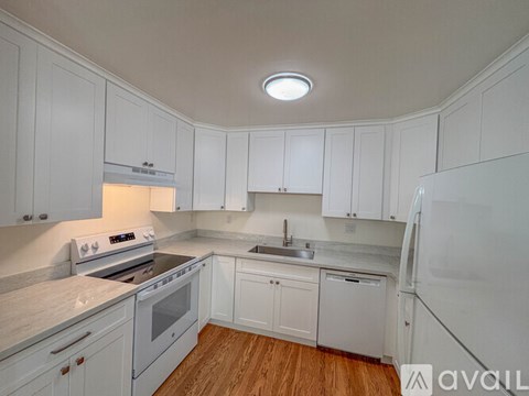 A kitchen with white cabinets and appliances.