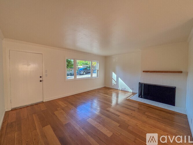 A room with a fireplace and wooden floors.